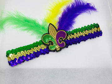 Diadema de lentejuelas con flor de lis morada, verde y dorada, y plumas